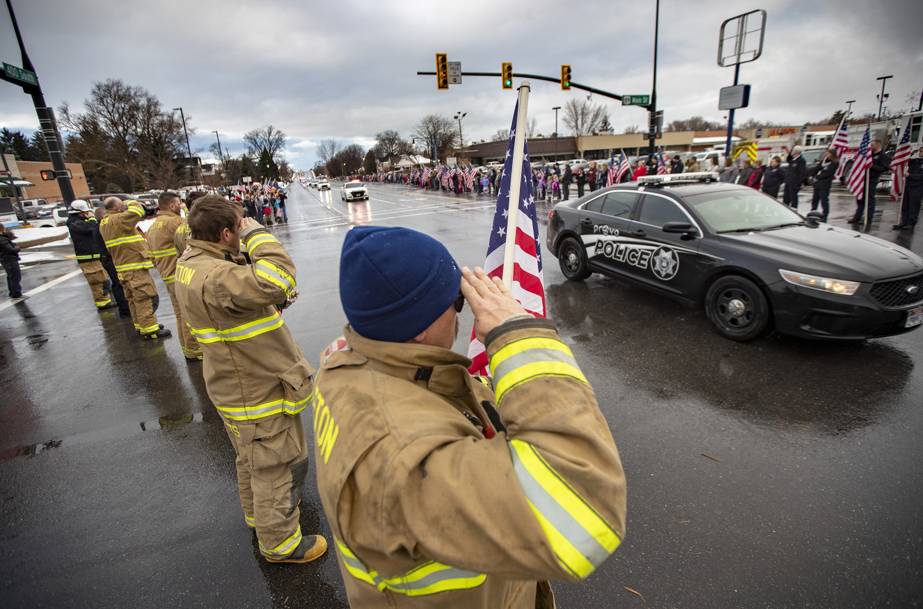 Mapleton firefighters salute as they join thousands lined up on 400 South and Main Street in Springville as Officer Joseph Shinners's body is brought back in a processional on Sunday, Jan. 6, 2019. (Photo: Scott G Winterton, KSL)