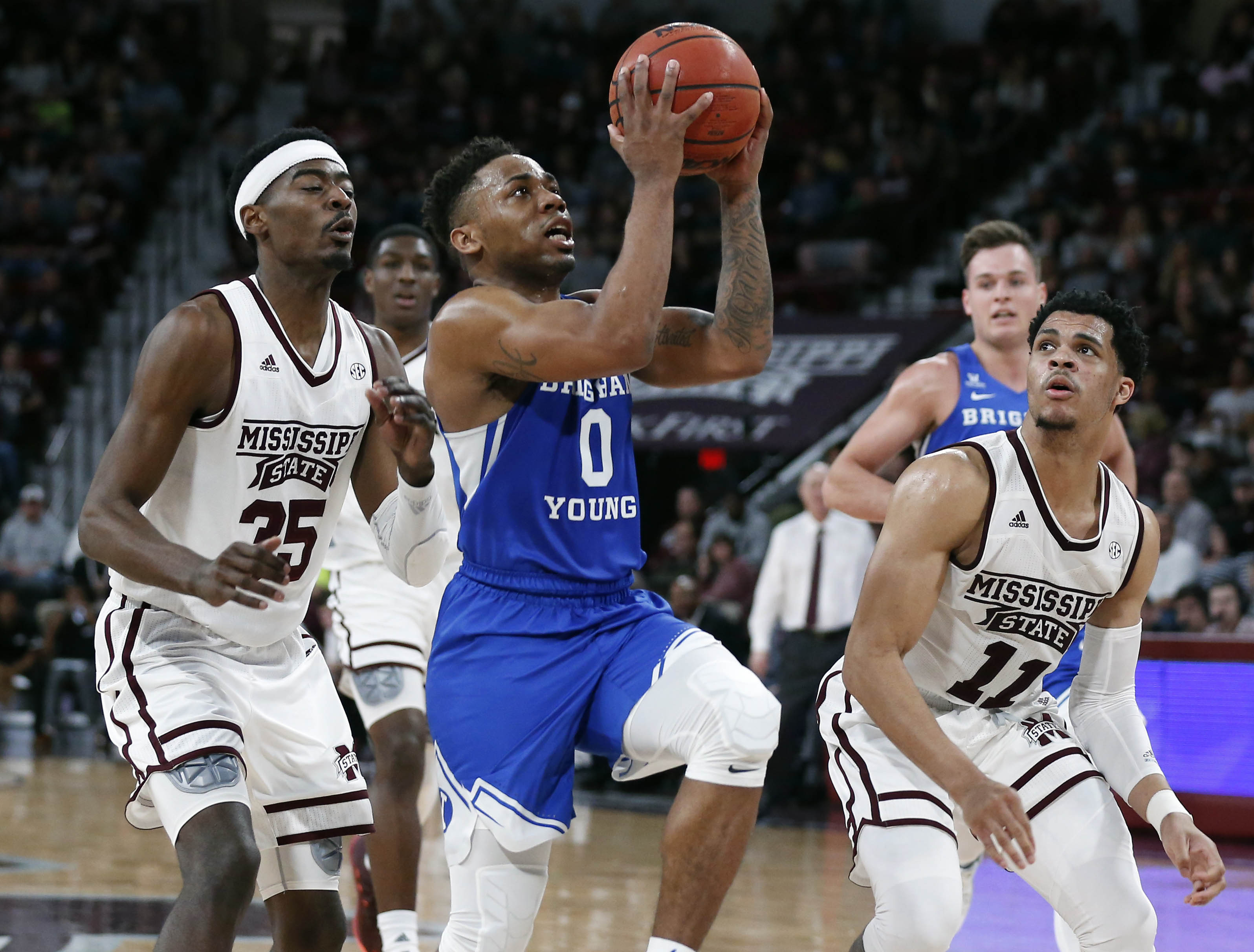 Brigham Young guard Jahshire Hardnett (0) leaps past Mississippi State forward Aric Holman (35) and guard Quinndary Weatherspoon (11) during the second half of an NCAA college basketball game in Starkville, Miss., Saturday, Dec. 29, 2018. Mississippi State won 103-81. (Photo: Rogelio V. Solis, AP)