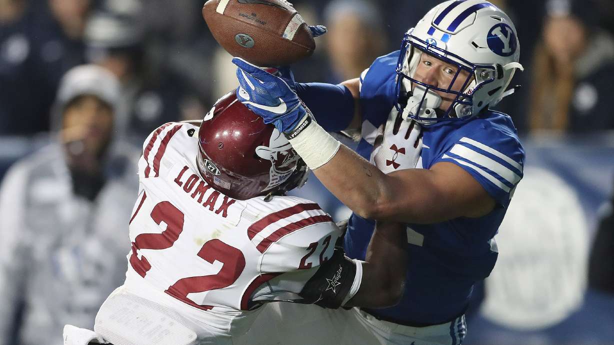 Brigham Young Cougars tight end Dallin Holker (32) tries to catch the pass under pressure from New Mexico State Aggies defensive back Shamad Lomax (22) in Provo on Saturday, Nov. 17, 2018.