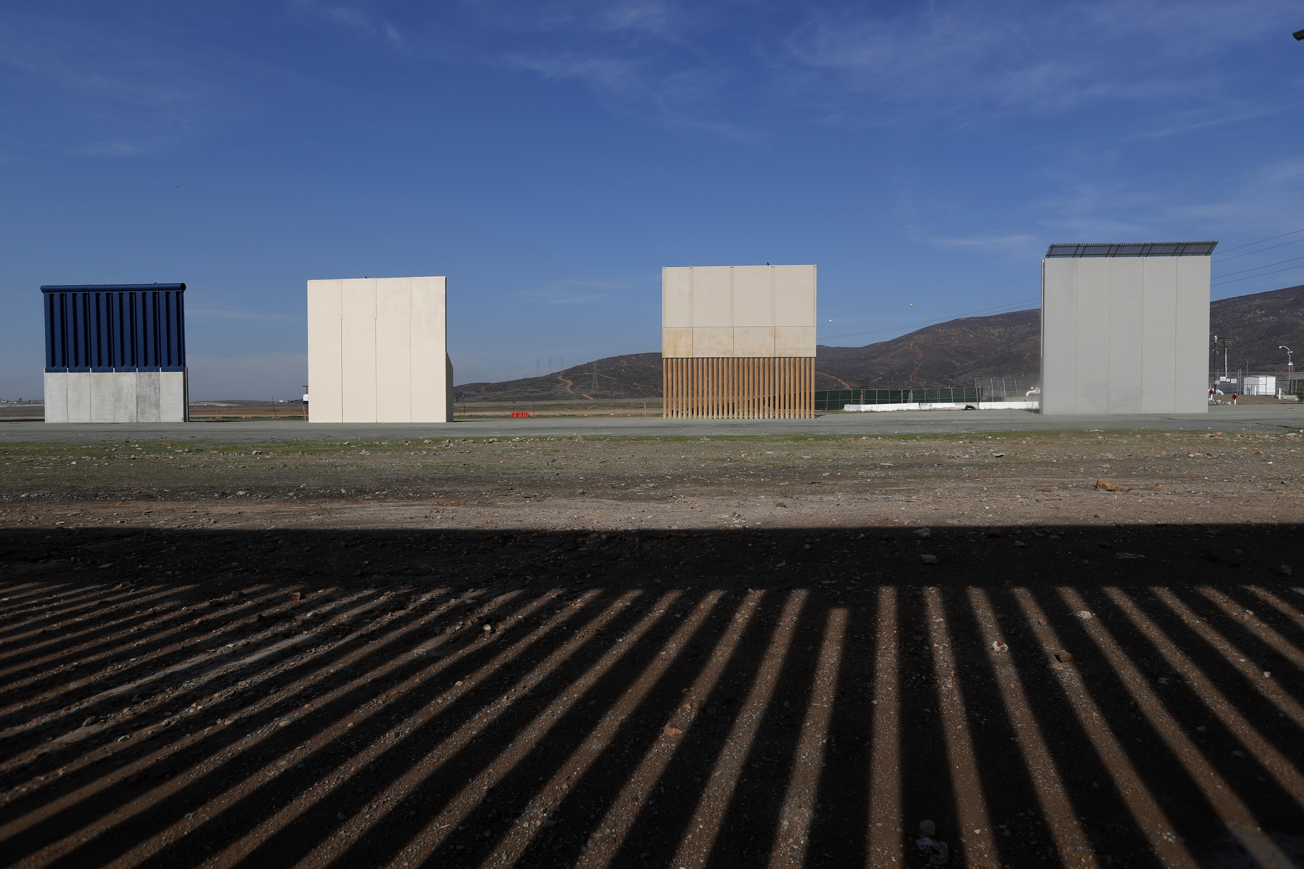 In this Wednesday, Dec. 12, 2018, file photo, border wall prototypes stand in San Diego near the Mexico-U.S. border, seen from Tijuana, Mexico, where the current wall casts a shadow in the foreground. (AP Photo/Moises Castillo, File)