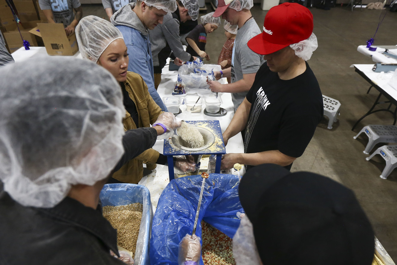 Chelsea Baugh, her husband and children help scoop ingredients into bags during the Feed My Starving Children event at the Salt Palace Convention Center in Salt Lake City on Wednesday, Jan. 9, 2019. About 1,300 volunteers from Vivint Smart Home packaged more than 272,000 meals to be sent to orphans in Third World countries. (Photo: Silas Walker, KSL)
