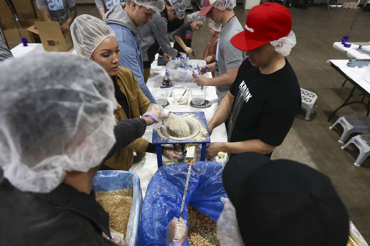Chelsea Baugh, her husband and children help scoop ingredients into bags during the Feed My Starving Children event at the Salt Palace Convention Center in Salt Lake City on Wednesday, Jan. 9, 2019. About 1,300 volunteers from Vivint Smart Home packaged more than 272,000 meals to be sent to orphans in Third World countries. (Photo: Silas Walker, KSL)