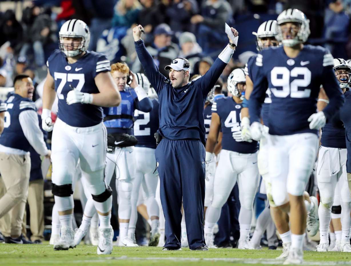 Offensive Line Coach Ryan Pugh celebrates after a play as BYU and Hawaii play at LaVell Edwards Stadium in Provo on Saturday, Oct. 13, 2018. BYU won 49-23.