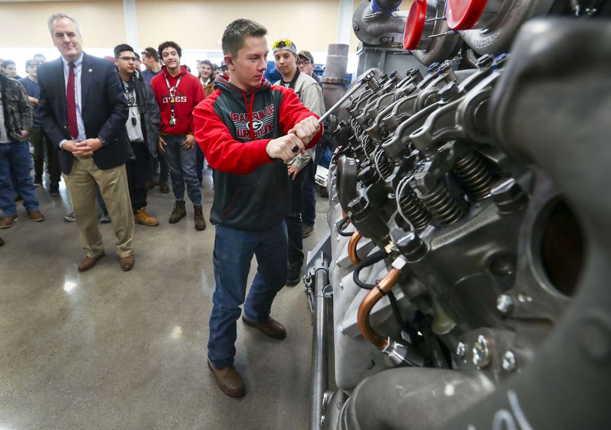 Val Hale, executive director of the Utah Governor’s Office of Economic Development, left, watches as Grantsville High School senior Seth Hicken tightens a rocker arm on a Detroit Diesel series 4000 V16 diesel engine at Detroit Diesel in Tooele on Wednesday, Jan. 23, 2019. (Photo: Steve Griffin, KSL)