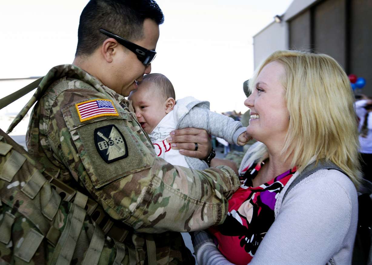 Utah Army National Guard Spc. Sati Sivongsa is handed his 6-month-old son, Rohnn, from his wife, Bridget, at the Utah Air National Guard’s Roland R. Wright Air Base in Salt Lake City on Thursday, Jan. 31, 2019, after the 65th Field Artillery Brigade returned from a more than 10-month deployment in the Middle East. (Photo: Laura Seitz, KSL)
