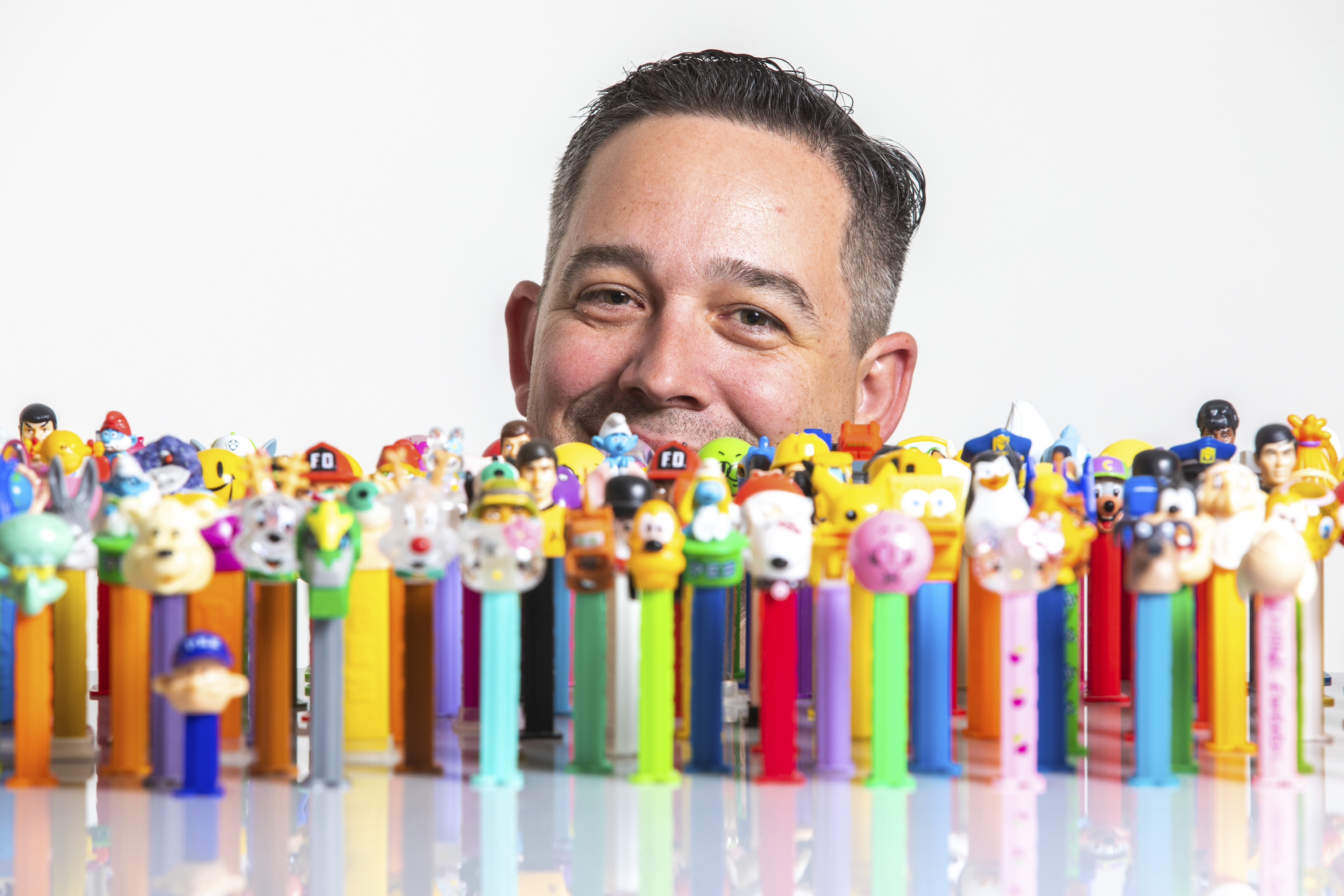 Justin Hansen, of host The PEZ Collection Podcast, sits for a portrait with part of his collection in Ogden, Utah, on Thursday, Jan. 31, 2019. (Ben Dorger/Standard-Examiner via AP)