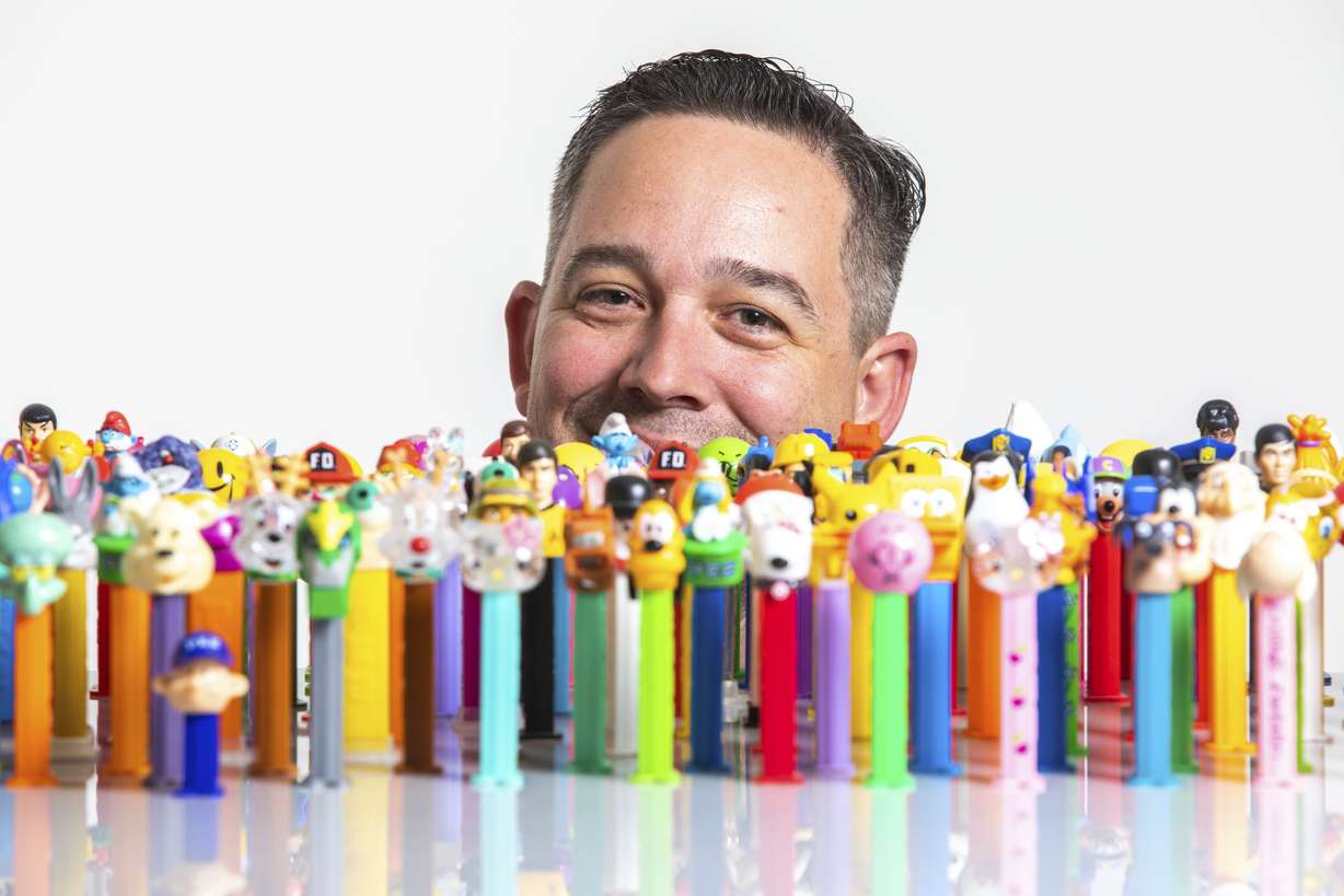 Justin Hansen, of host The PEZ Collection Podcast, sits for a portrait with part of his collection in Ogden, Utah, on Thursday, Jan. 31, 2019. (Ben Dorger/Standard-Examiner via AP)