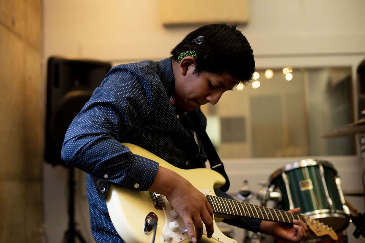 Eli Sackett, a student at the Utah Schools for the Deaf and the Blind, plays guitar in a studio at Spy Hop in Salt Lake City on Friday, Feb. 15, 2019. Sackett is visually impaired and wears two cochlear implants to help him hear. (Photo: Laura Seitz, KSL)