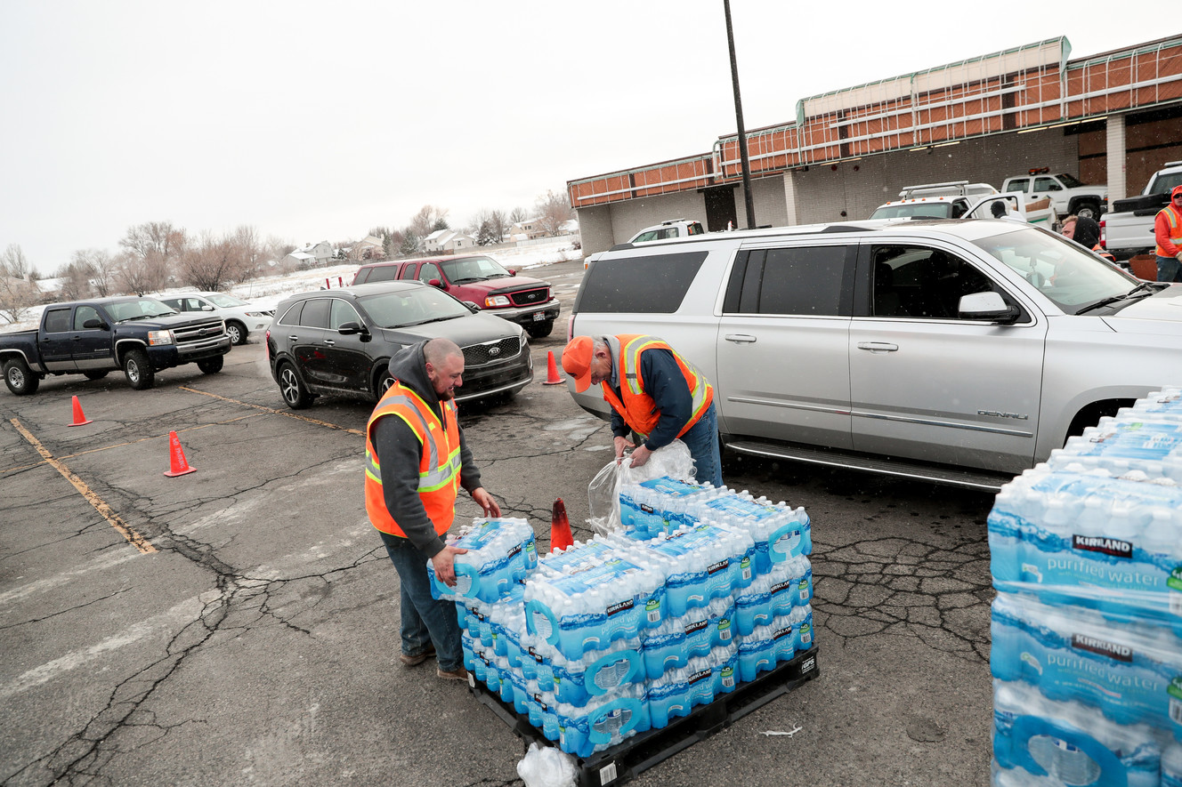 Sandy city employees Taylor Vick and Mike Fox distribute water to residents at a staging area on 700 East in Sandy on Saturday, Feb. 16, 2019. Residents in a portion of Sandy have been instructed not to use their tap water due to lead and copper contamination. Photo: Spenser Heaps, KSL