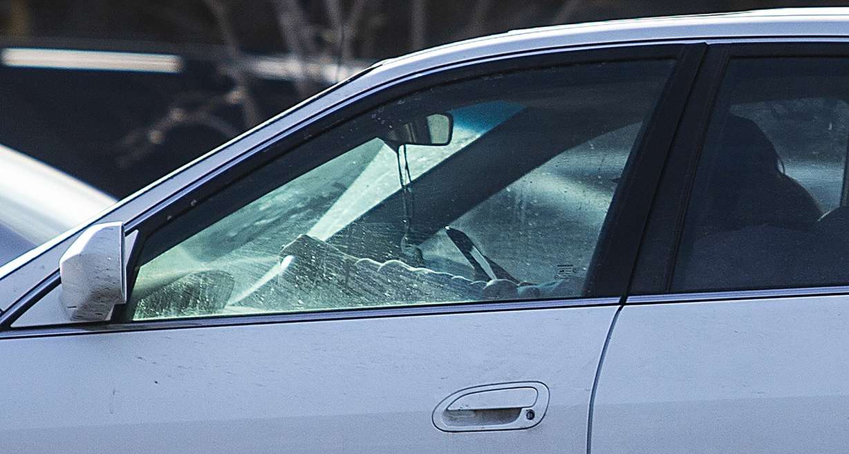 A driver holds her cellphone up as she drives on State Street in Salt Lake City on Monday, Feb. 25, 2019. (Photo: Scott G Winterton, KSL)