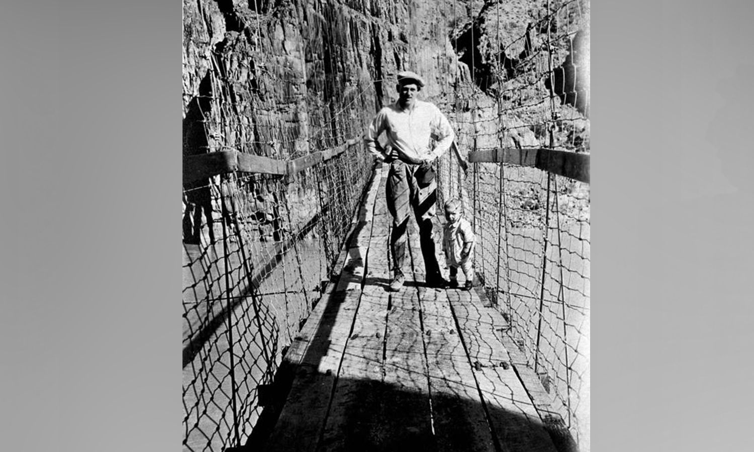 Three men crossing a crude suspension bridge that was constructed in Grand Canyon National Park in 1921. The bridge was attached to a stone cliff on the other side. (Photo: National Park Service)