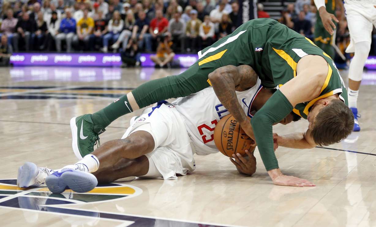 Utah Jazz guard Kyle Korver, top, and Los Angeles Clippers guard Lou Williams (23) battle for a loose ball in the first half during an NBA basketball game Wednesday, Feb. 27, 2019, in Salt Lake City. (AP Photo/Rick Bowmer)