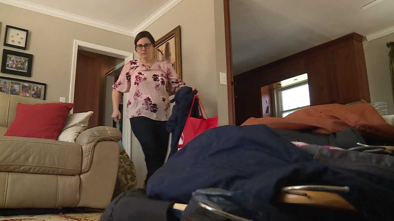 Elisa Albury clears out a hallway closet to sort the contents by category. Photo: KSL TV