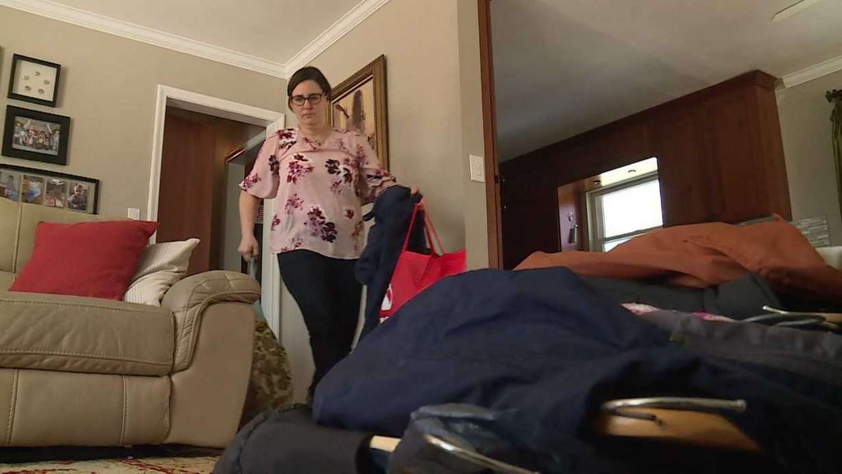 Elisa Albury clears out a hallway closet to sort the contents by category. Photo: KSL TV