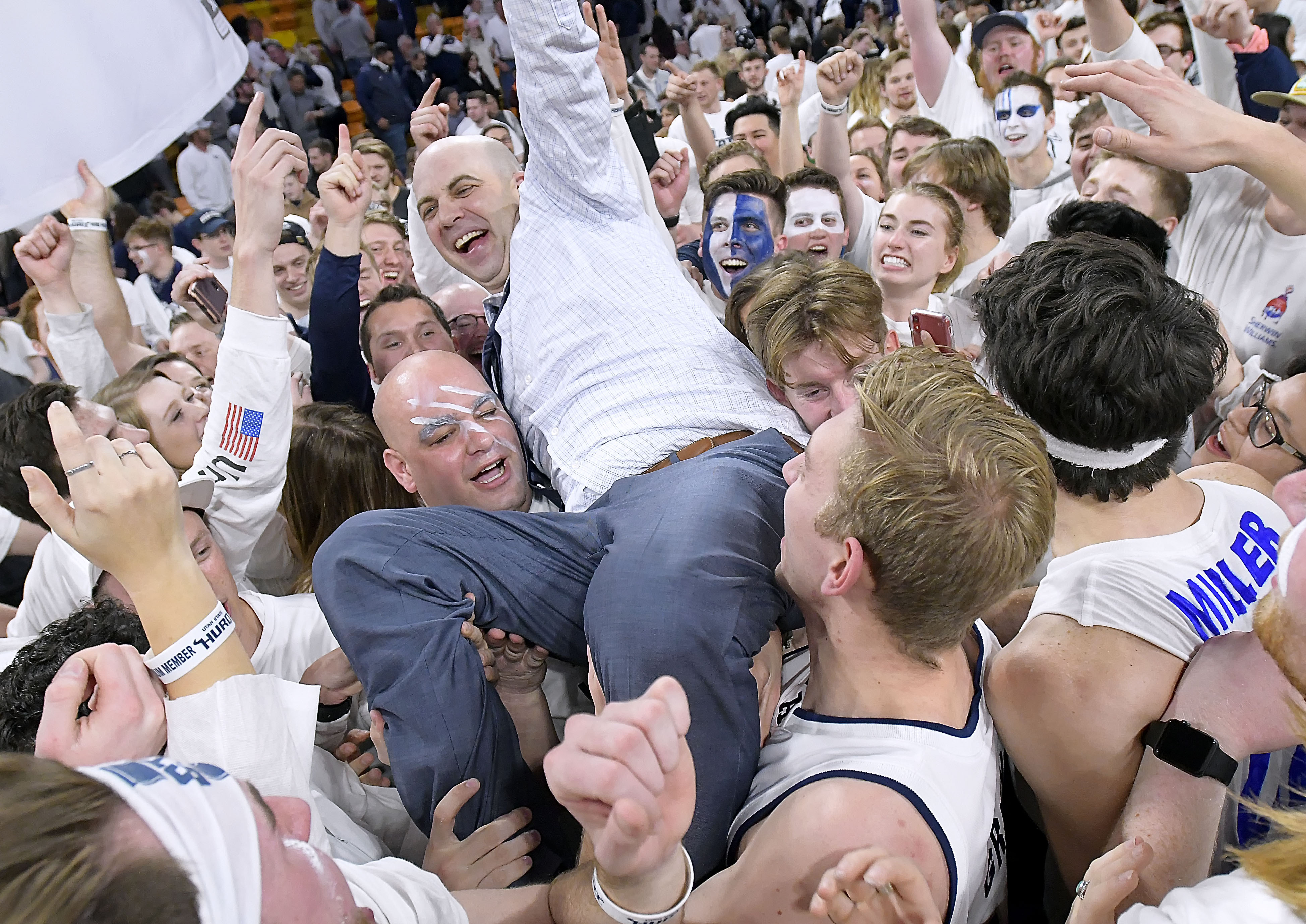 Utah State coach Craig Smith celebrates with fan on the court after Utah State defeated No. 12 Nevada 81-76 in an NCAA college basketball game Saturday, March 2, 2019, in Logan, Utah. (Eli Lucero/The Herald Journal via AP)