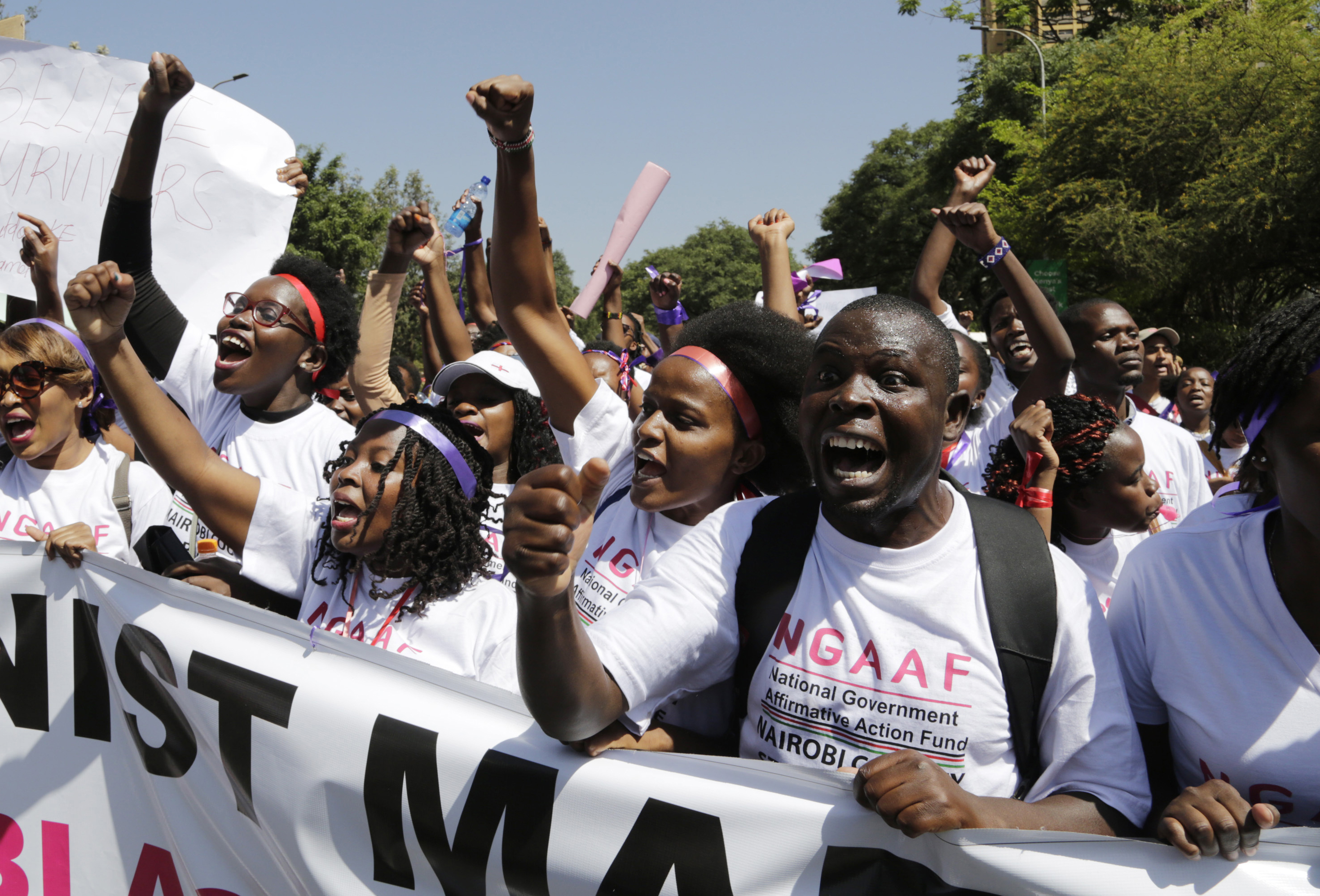Kenyan people shout slogans during a march to mark International Women's Day in Nairobi, Kenya, Friday March 8, 2019. Hundreds of women marched in downtown Nairobi highlighting domestic violence, sexual attacks and discrimination in jobs and wages. (AP Photo/Khalil Senosi)