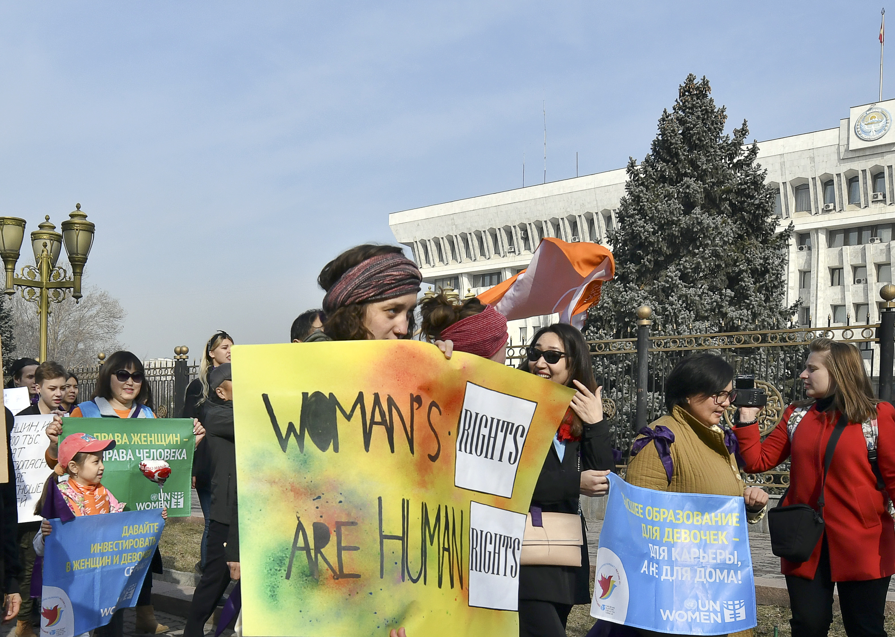 People march through the center of Kyrgyzstan's capital Bishkek, with the government building on the right, on Friday, March 8, 2019. Millions across the globe are marking International Women’s Day by demanding a gender-balanced world amid persistent salary gap, violence and widespread inequality. (AP Photo/Vladimir Voronin)