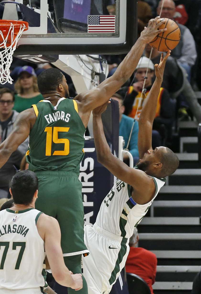 Utah Jazz forward Derrick Favors (15) defends against Milwaukee Bucks forward Khris Middleton (22) during the first half of an NBA basketball game Saturday, March 2, 2019, in Salt Lake City. (AP Photo/Rick Bowmer)