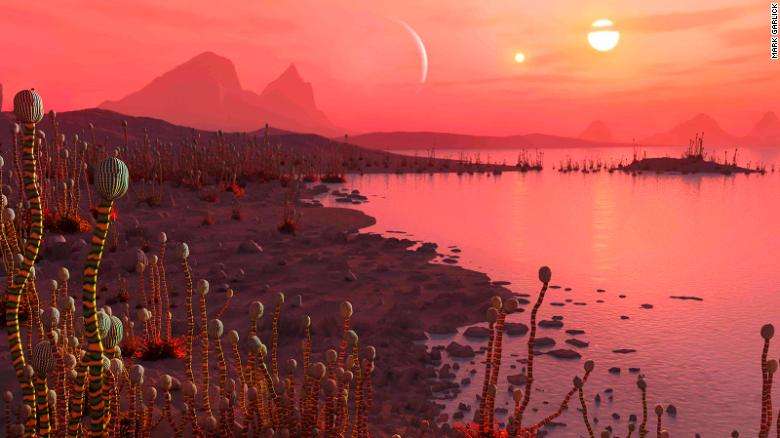 Artist's impression of life on a planet in orbit around a binary star system, visible as two suns in the sky; Mark Garlick via CNN