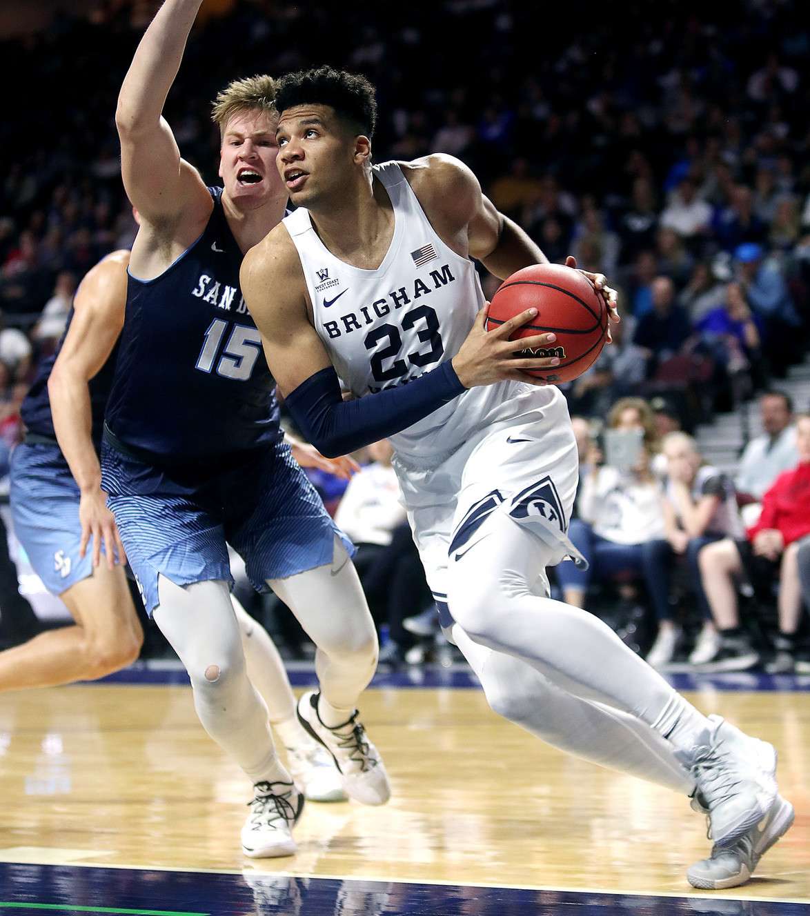 BYU forward Yoeli Childs (23) drives around San Diego forward Alex Floresca (15) as the BYU Cougars and San Diego Toreros play in WCC tournament action at the Orleans Arena in Las Vegas on Saturday, March 9, 2019. (Photo: Scott G Winterton, KSL)