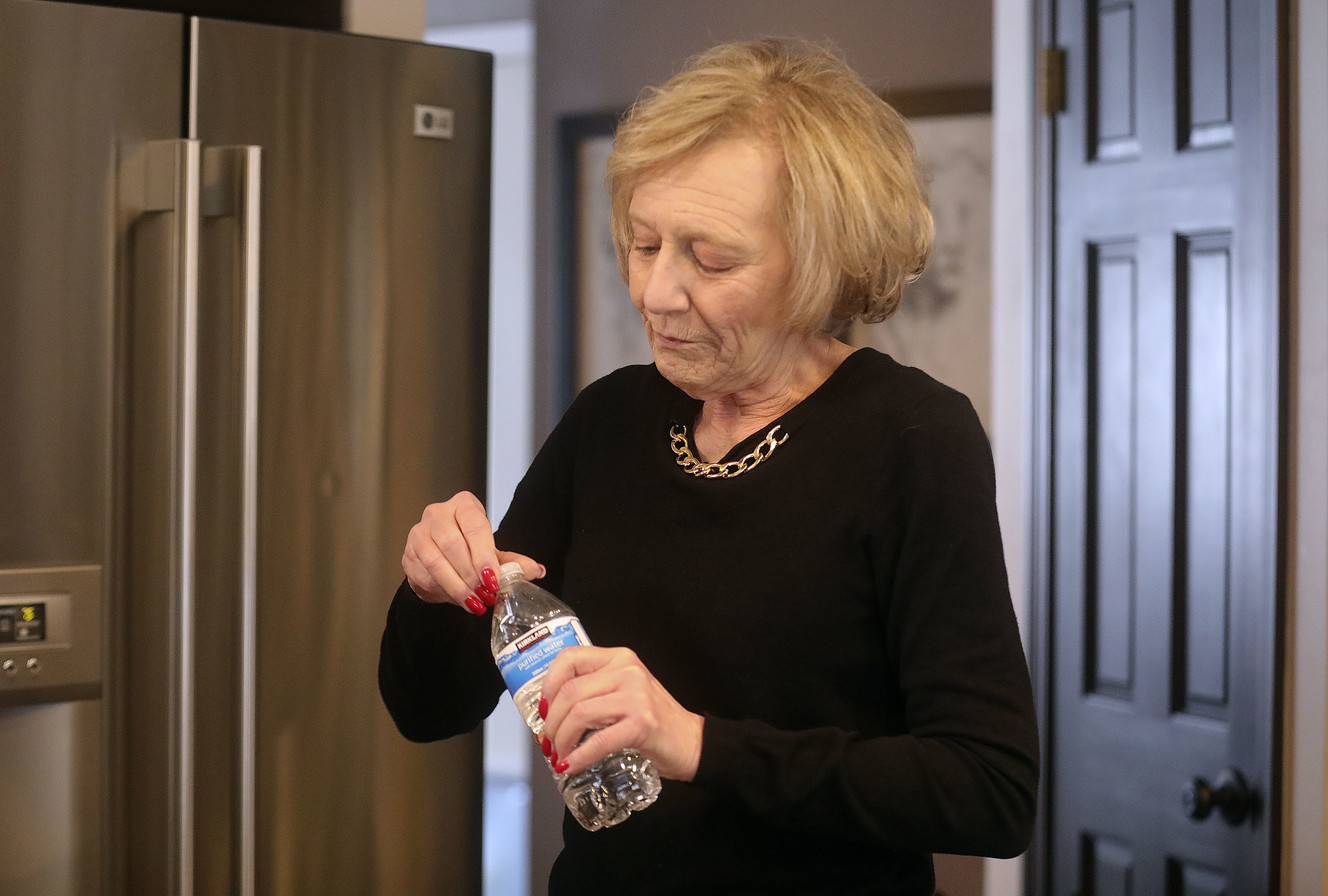 Kathe Bolan, whose water is contaminated, drinks a bottle of water at her home in Sandy on Thursday, March 14, 2019. (Photo: Kristin Murphy, KSL)