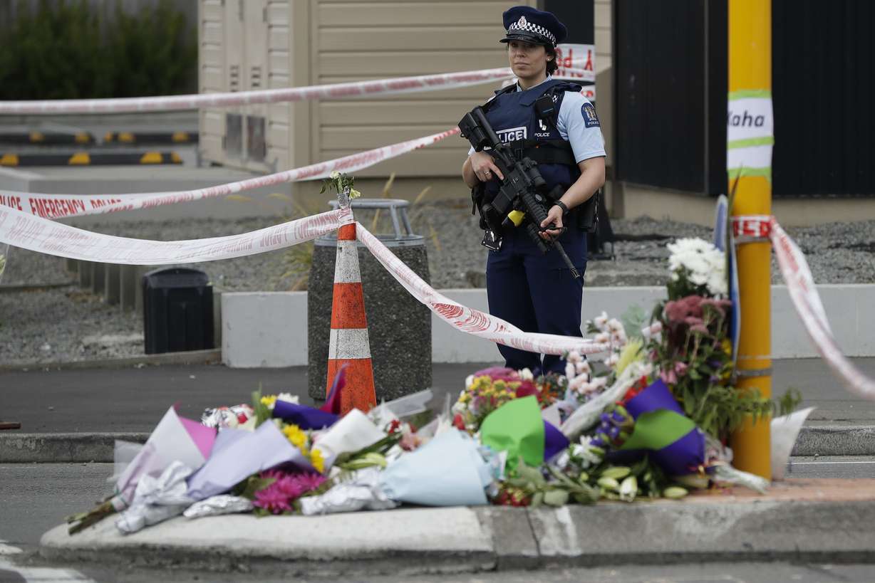 Police stand by makeshift memorial near the Linwood Mosque in Christchurch, New Zealand, Saturday, March 16, 2019, where one of the two mass shootings occurred. (AP Photo/Mark Baker)
