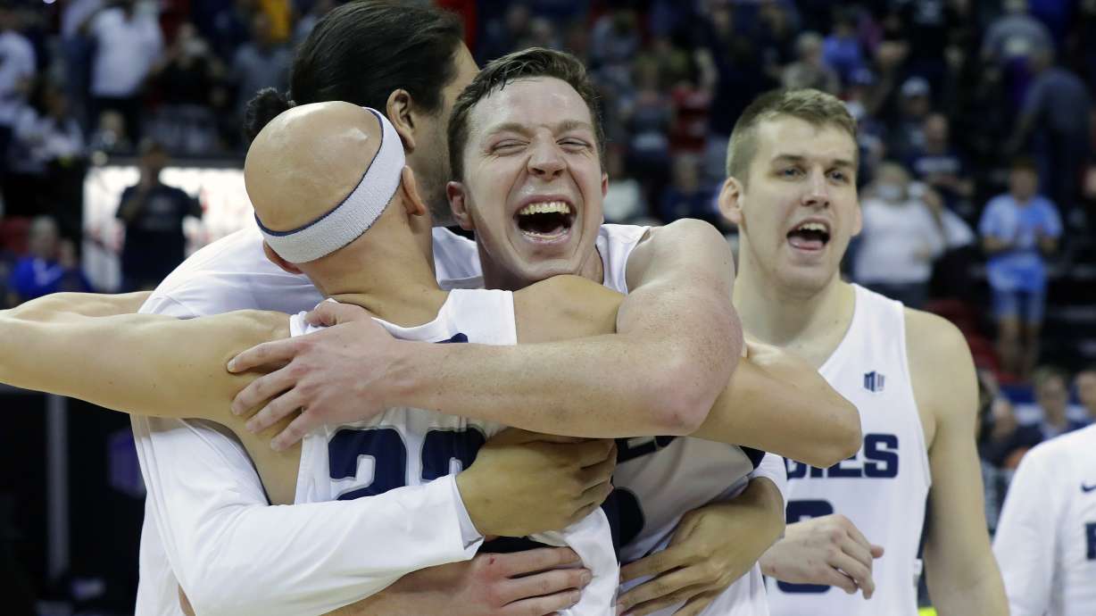 Utah State's Brock Miller, center, celebrates with teammates following an NCAA college basketball game against San Diego State in the Mountain West Conference men's tournament championship, March 16, 2019, in Las Vegas. Miller played for the first time since Dec. 29 in the Aggies' win over New Mexico.