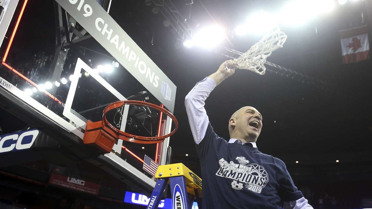 Utah State's head coach Craig Smith swings the net after defeating San Diego State in an NCAA college basketball game in the Mountain West Conference men's tournament championship Saturday, March 16, 2019, in Las Vegas. (AP Photo/Isaac Brekken)