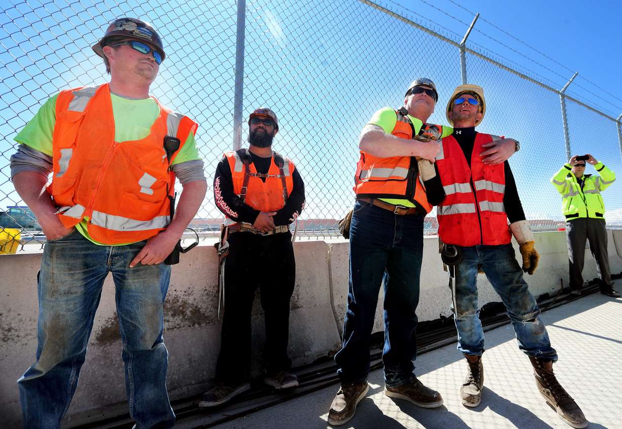 Patric Brown, Samiu Lomu, Kraig Iverson and Heath Hoskins watch as the final beam is placed on the north concourse at the Salt Lake City International Airport during a topping-off ceremony on Tuesday, March 19, 2019. (Photo: Scott G Winterton, KSL)