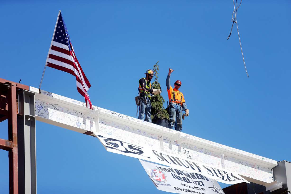 Steelworkers Devin Barnes and Dustin Steele stand on the final beam on the north concourse at the Salt Lake City International Airport during a topping-off ceremony on Tuesday, March 19, 2019. (Photo: Scott G Winterton, KSL)