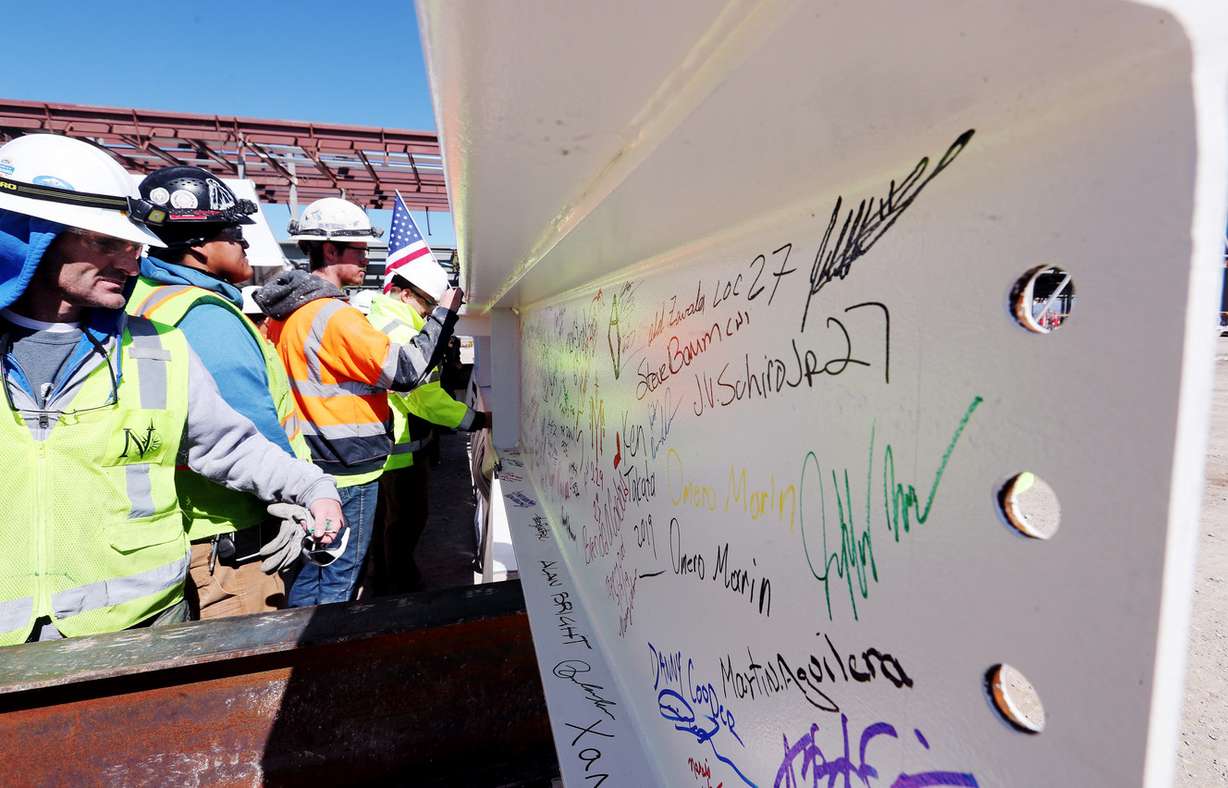 Workers sign the final beam to be placed on the north concourse at the Salt Lake City International Airport is pictured with an American flag during a topping-off ceremony on Tuesday, March 19, 2019. (Photo: Scott G Winterton, KSL)