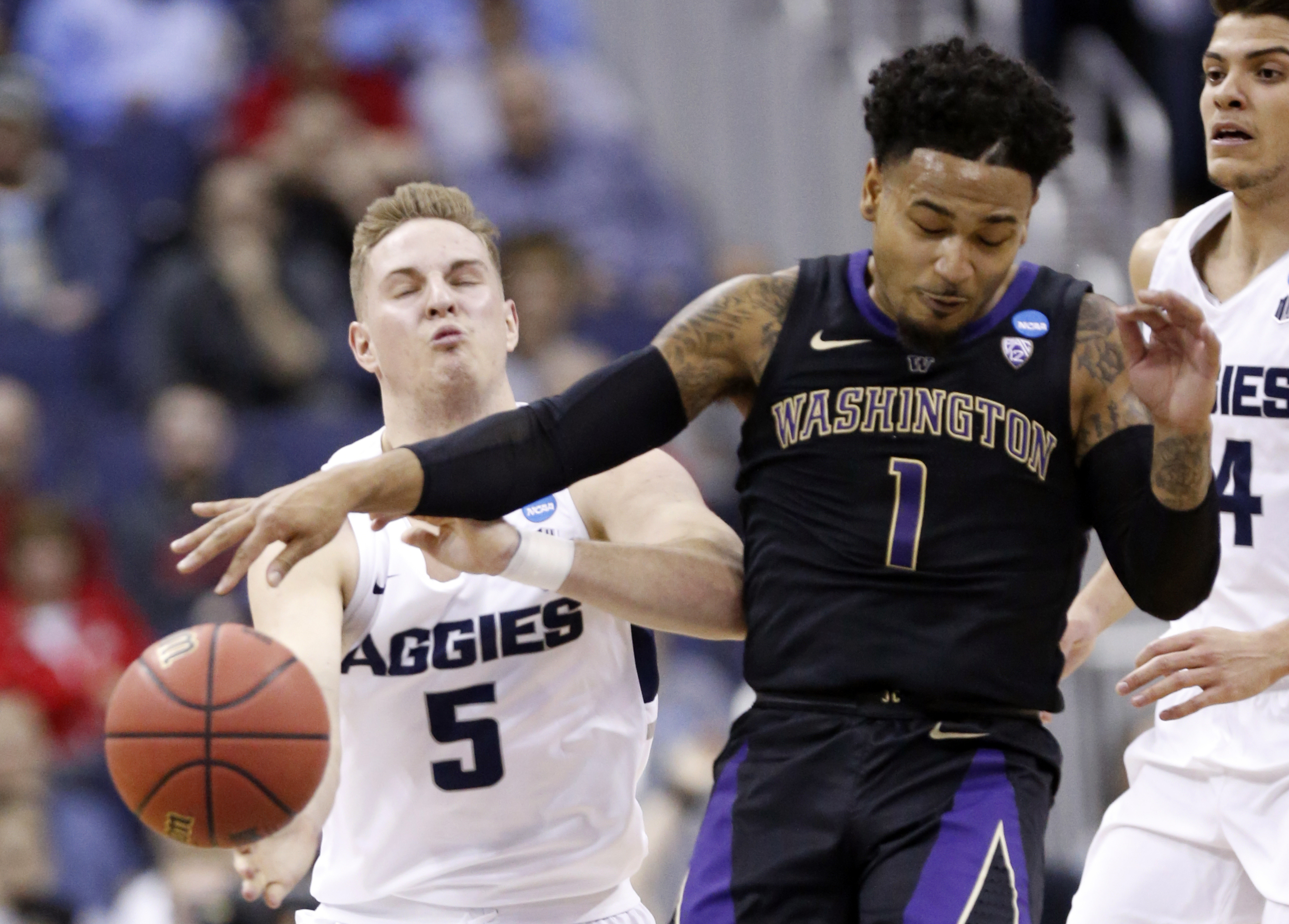Washington's David Crisp (1) and Utah State's Sam Merrill (5) battle for the ball in the first half during a first round men's college basketball game in the NCAA Tournament in Columbus, Ohio, Friday, March 22, 2019. (Photo: Paul Vernon, AP)