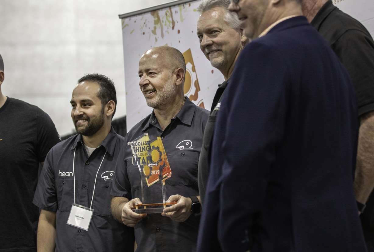 Mark Harling, center, and other employees of Salt Lake City-based Bean Trailer pose for a photo with Todd Bingham, president and CEO of Utah Manufacturers Association and other sponsors during We Are The Utah Manufacturers Association Expo at the Mountain America Exposition Center in Sandy on Wednesday, March 27, 2019. Bean Trailer was the first winner of the "Coolest Product Made in Utah" contest. (Photo: Carter Williams, KSL.com)