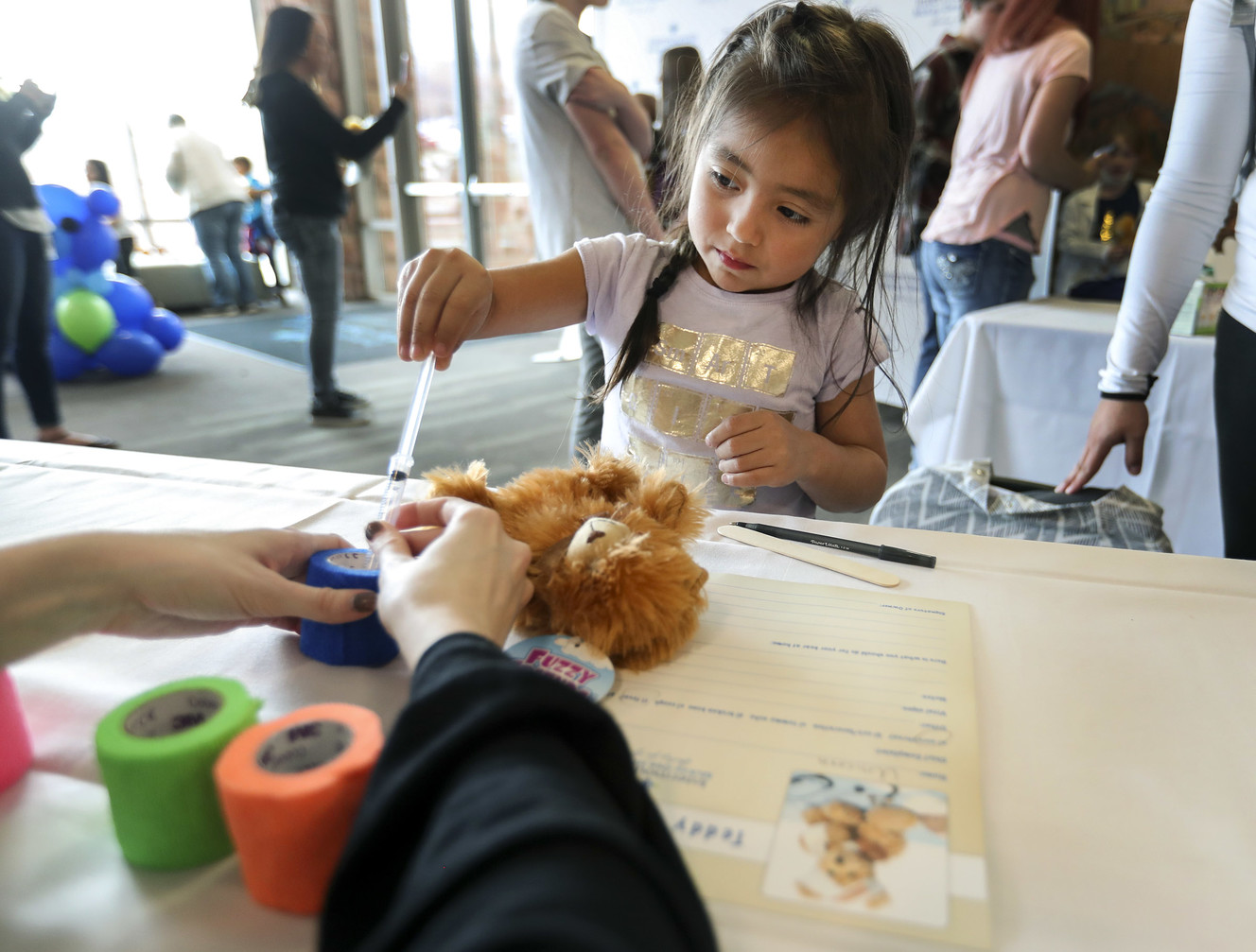 With the help of Leticia Clegg, a certified child life specialist, Kaylee Cruz, 4, gives her teddy bear some medicine as she attends the Teddy Bear Clinic and Picnic at McKay-Dee Hospital in Ogden on Wednesday, March 27, 2019. Children were given teddy bears and then went to a doctor's visit for the toys. The Teddy Bear Clinic is meant to help teach the importance of health to kids. Photo: Steve Griffin, KSL
