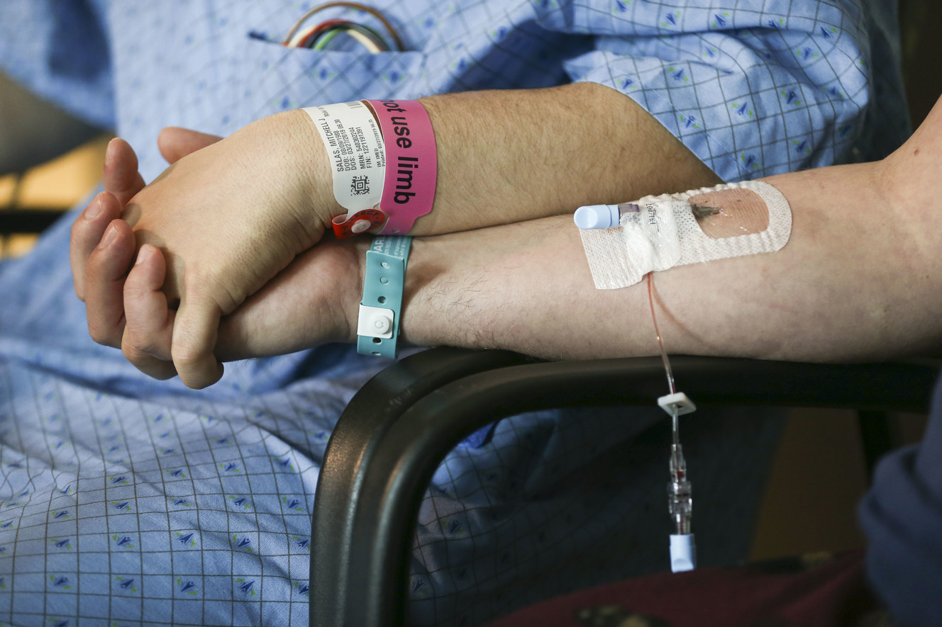 Kidney donor Matthew Thompson holds the hand of Mitchell Salas, left, who received his kidney two days earlier at Intermountain Medical Center in Murray on Friday, March 29, 2019. Thompson and Salas met for the first time at the hospital after their surgeries. (Photo: Silas Walker, KSL)