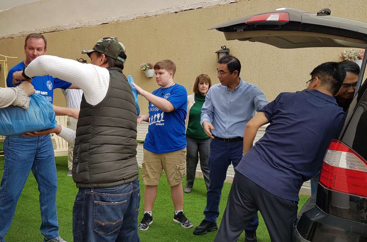 Local Church members and friends are loading a car with food packages they’ve assembled to support a volunteer community food aid program. (Photo: Intellectual Reserve)