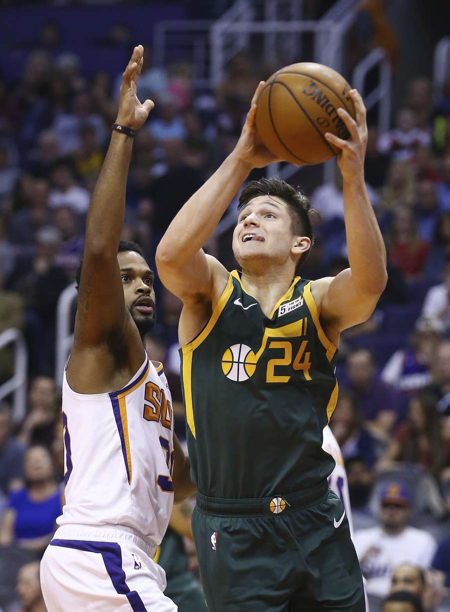 Utah Jazz guard Grayson Allen (24) slips past Phoenix Suns guard Troy Daniels, left, to score during the second half of an NBA basketball Wednesday, April 3, 2019, in Phoenix. The Jazz defeated the Suns 118-97. (AP Photo/Ross D. Franklin)