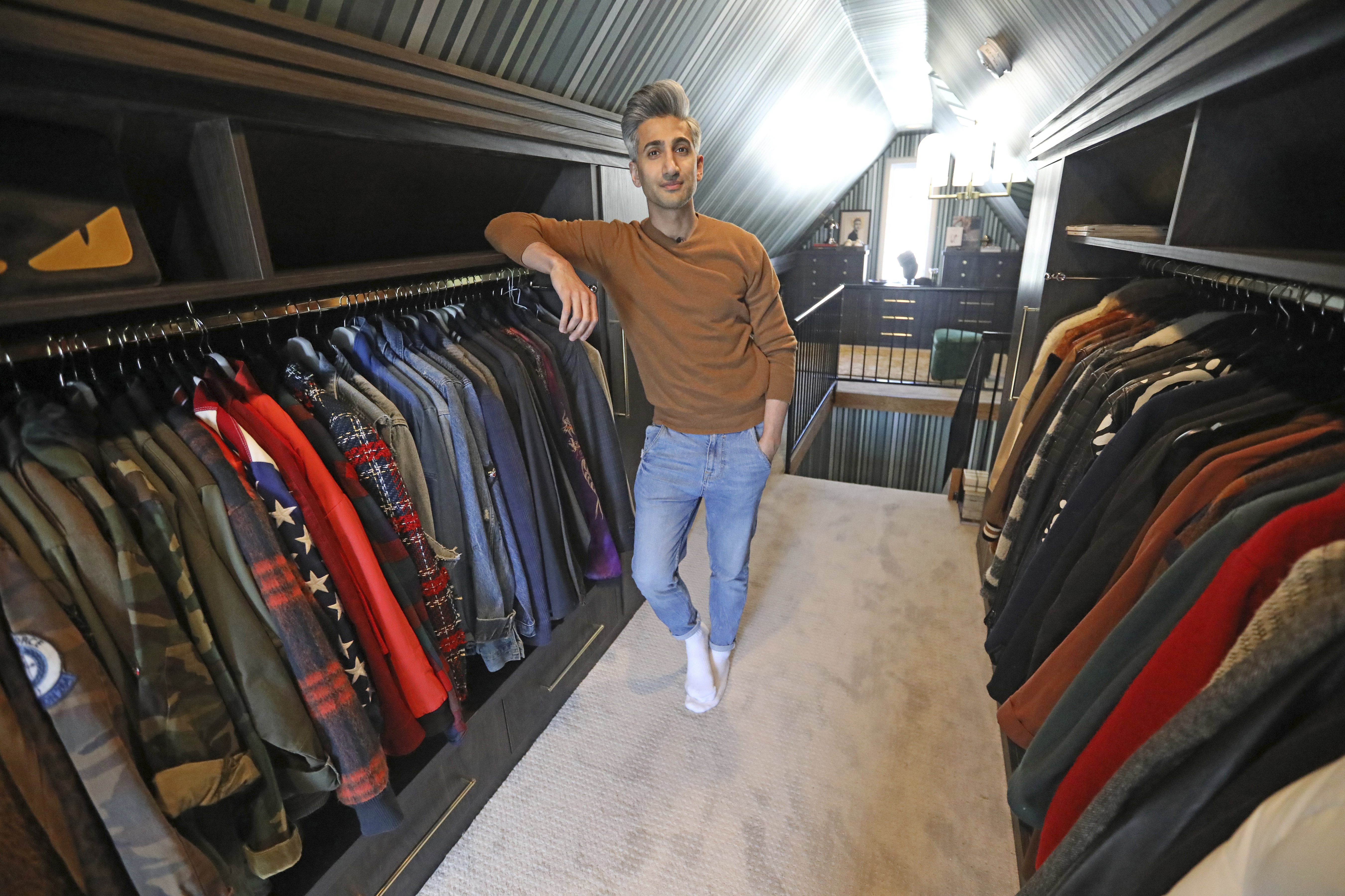 In this March 15, 2019, photo, Tan France, a cast member on the Netflix series "Queer Eye," poses among his clothes in the attic of his home in Salt Lake City. (AP Photo/Rick Bowmer)