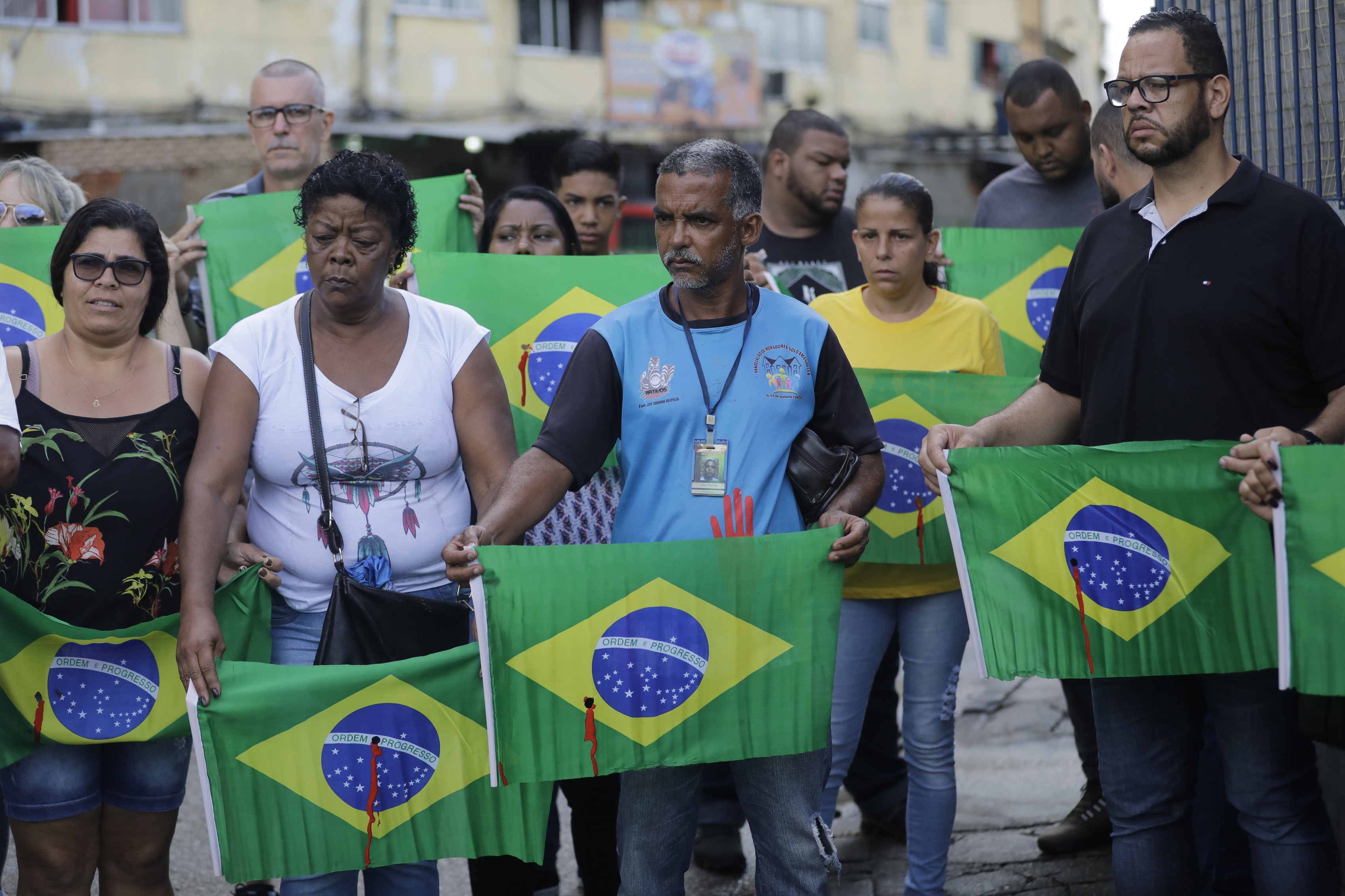 Red-stained Brazil flags at burial of man shot by military