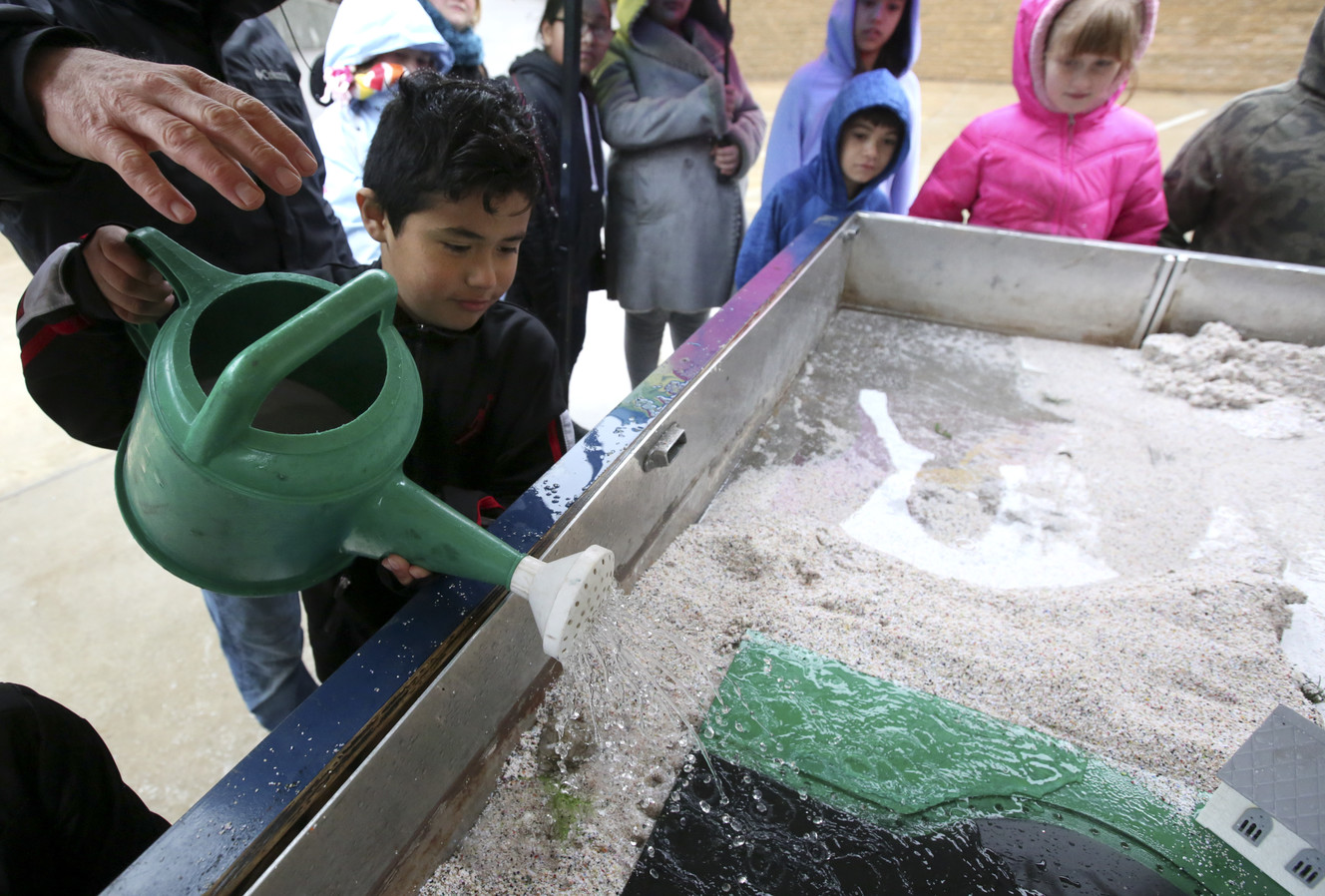 Fabian Matus pours water into the USU Extensions Stream Hydrology Trailer to simulate rainwater during the 13th Annual Salt Lake County Stormwater Coalition 4th Grade Water Quality Fair at Utah's Hogle Zoo in Salt Lake City on Tuesday, April 9, 2019. (Photo: Kristin Murphy, KSL)
