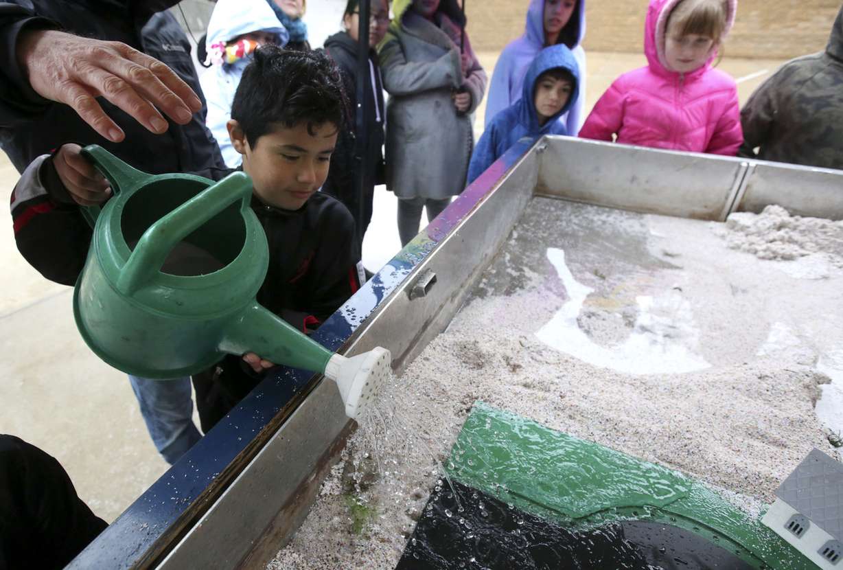 Fabian Matus pours water into the USU Extensions Stream Hydrology Trailer to simulate rainwater during the 13th Annual Salt Lake County Stormwater Coalition 4th Grade Water Quality Fair at Utah's Hogle Zoo in Salt Lake City on Tuesday, April 9, 2019. (Photo: Kristin Murphy, KSL)