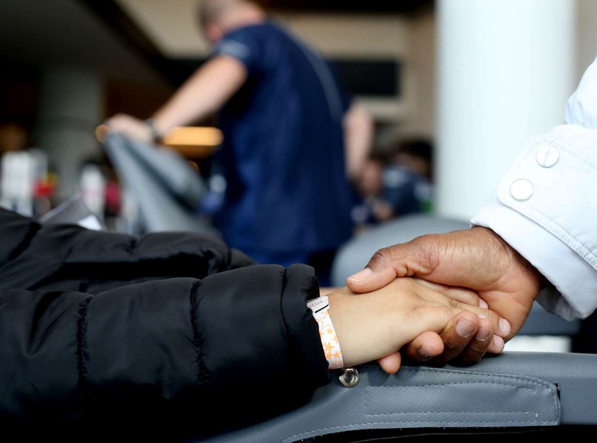 A mother comforts her son while he has a cavity filled during a dental exam at Vivint Smart Home Arena in Salt Lake City on Thursday, April 11, 2019. The Utah Jazz and TeamSmile partnered to provide complimentary dental care for underprivileged students. Since the Jazz and TeamSmile began working together in 2015, the volunteer dentists and dental hygienists have performed $300,000 worth of dental work — including cleanings, fillings, sealants and extractions — at no charge. (Photo: Laura Seitz, KSL)