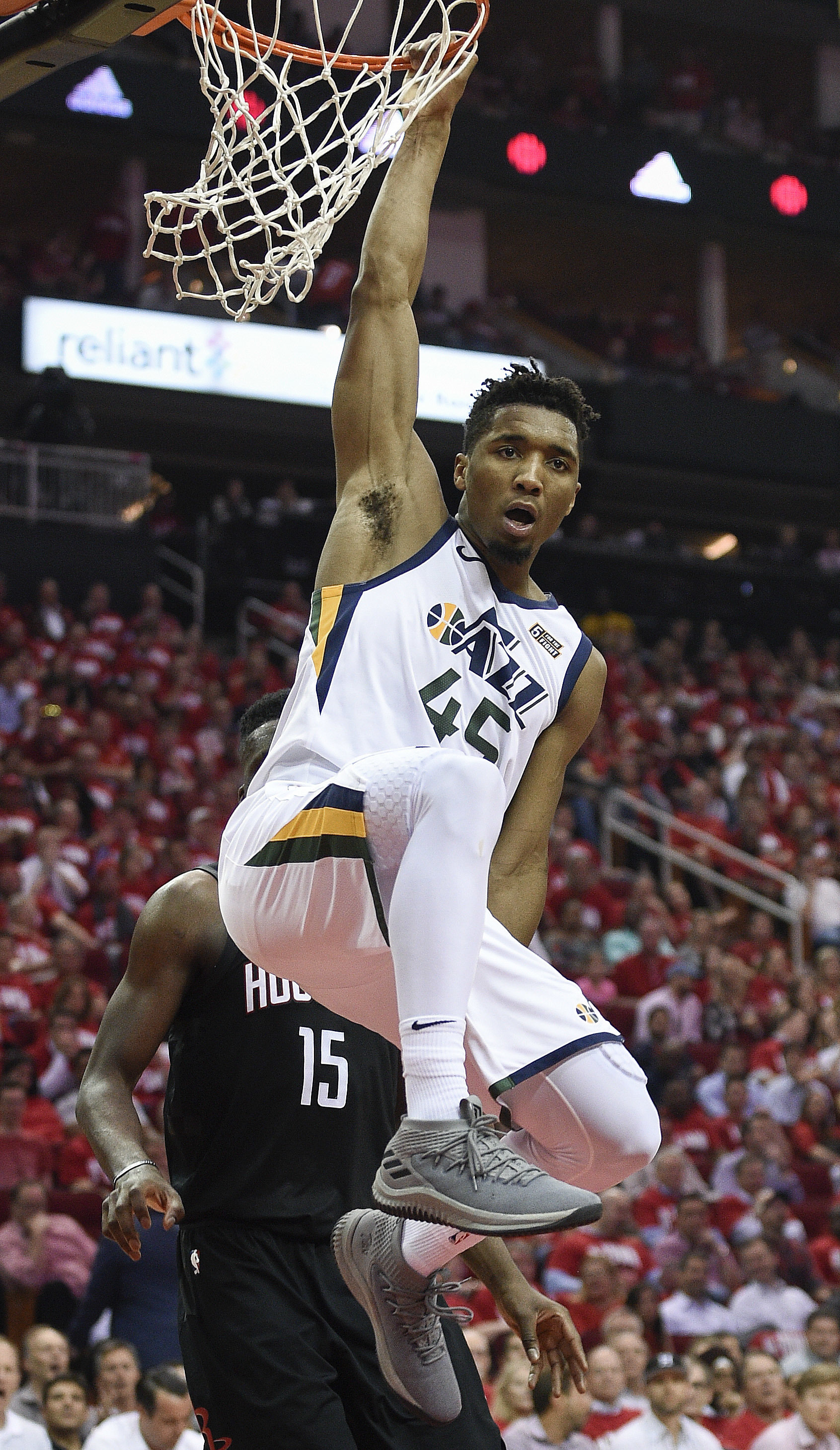 Utah Jazz guard Donovan Mitchell hangs from the rim after his dunk during the second half in Game 2 of an NBA basketball second-round playoff series against the Houston Rockets, Wednesday, May 2, 2018, in Houston. (AP Photo/Eric Christian Smith)