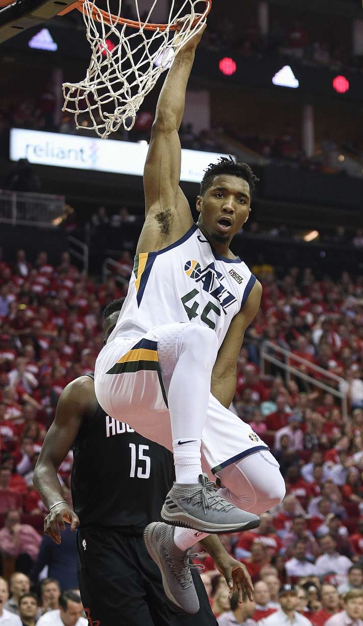 Utah Jazz guard Donovan Mitchell hangs from the rim after his dunk during the second half in Game 2 of an NBA basketball second-round playoff series against the Houston Rockets, Wednesday, May 2, 2018, in Houston. (AP Photo/Eric Christian Smith)