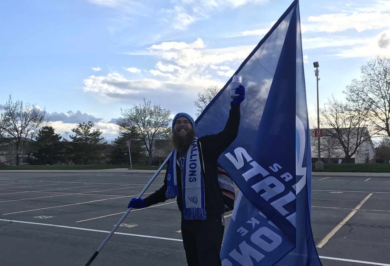 Stallions fan Jarrett Miller holds a flag over his head as Salt Lake Stallions fans gather for one final tailgate, Friday, April 12, 2019 near Rice-Eccles Stadium. The team, which disbanded two weeks ago, was scheduled to play their final regular-season game Friday against the San Diego Fleet. (Photo: Sean Walker, KSL.com)
