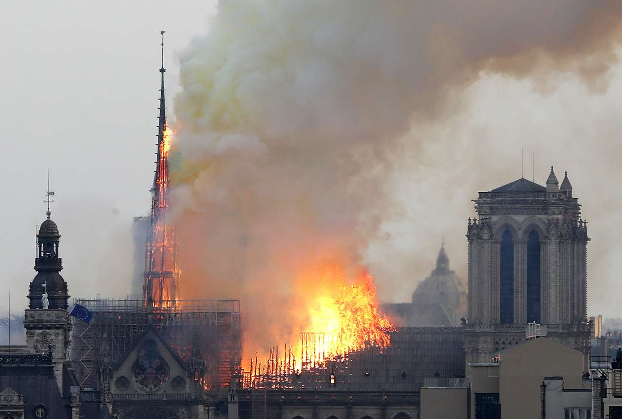 Flames rise from Notre Dame cathedral as it burns in Paris, Monday, April 15, 2019. Massive plumes of yellow brown smoke is filling the air above Notre Dame Cathedral and ash is falling on tourists and others. Photo: AP Photo