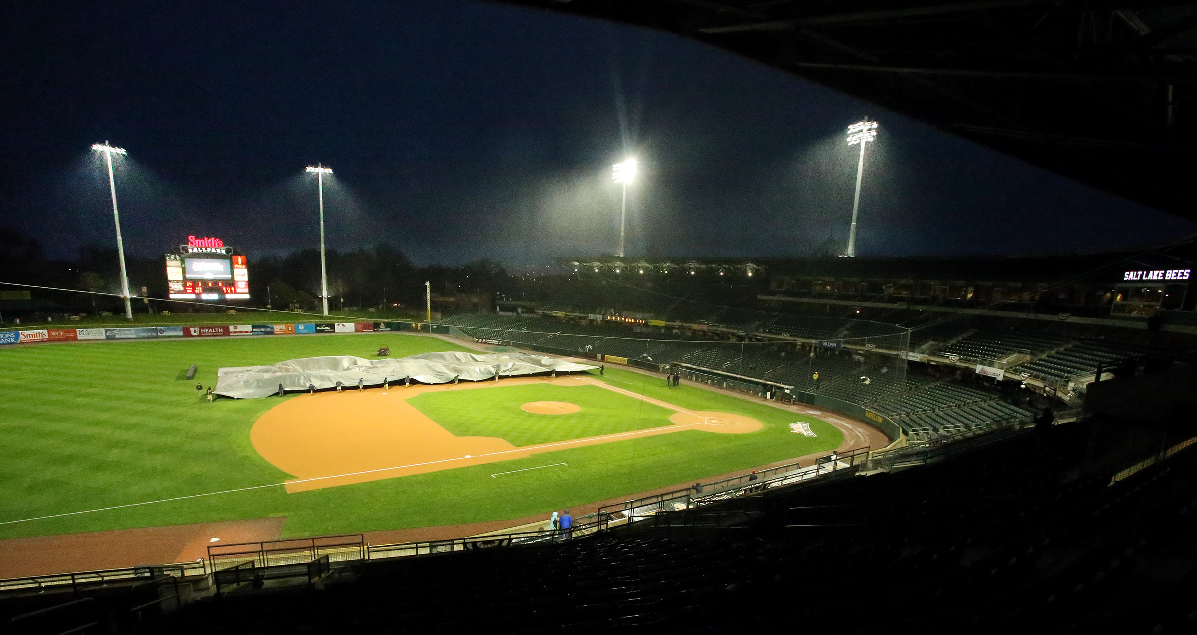 Grounds crew members pull the tarp over the infield as rain causes a delay at the Salt Lake Bees and the Fresno Grizzlies game at Smith's Ballpark in Salt Lake City on Wednesday, April 10, 2019. The Bees have already had more rainouts in the first week of 2019 than all of 2018. (Photo: Scott G. Winterton, KSL, File)