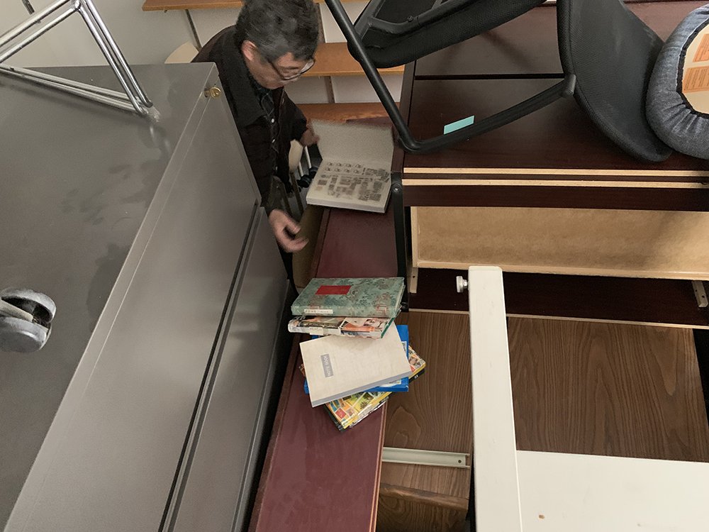 University of Utah Professor Minqi Li looks through his decades-old stamp collection after recovering it with the help of U. Police Sgt. Mark Veatupu at the university on Monday, April 22, 2019. (Photo: University of Utah Department of Public Safety)