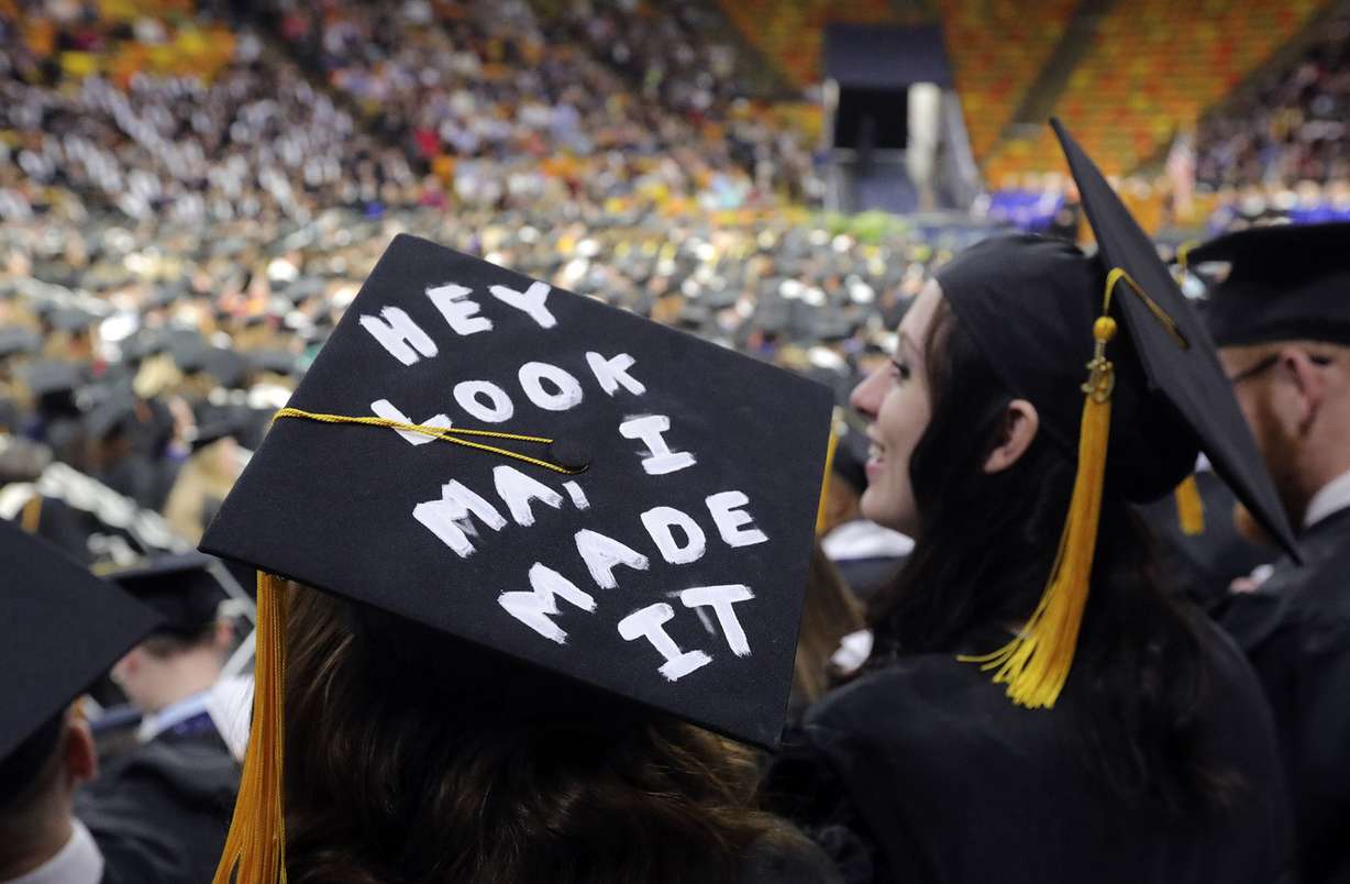 Becca Betz wears a note to her mother on her cap during Utah State University's commencement ceremony at the Dee Glen Smith Spectrum in Logan on Thursday, May 2, 2019. Chloe Dryden is next to her. (Photo: Kristin Murphy, KSL)