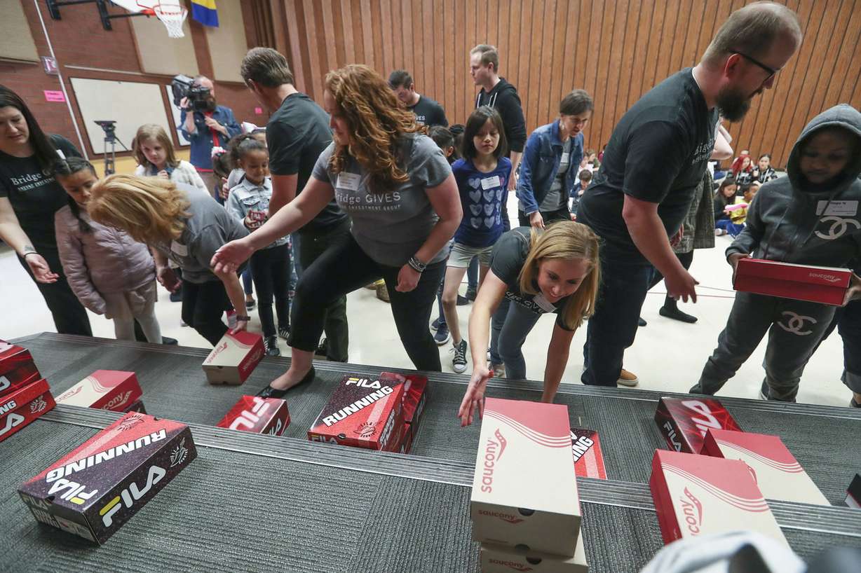 M. Lynn Bennion Elementary School students receive new athletic shoes from Bridge Investment Group employees during the “Bridge Boots-on-the-Ground” program in Salt Lake City on Thursday, May 9, 2019. Bridge Investment Group and Shoes That Fit have partnered and are sponsoring six elementary schools nationwide. The program will give over 1,200 children new shoes. Along with other partners, Shoes That Fit delivered new athletic shoes to approximately 131,000 children in more than 2,500 schools across 48 states last year. (Photo: Steve Griffin, KSL)